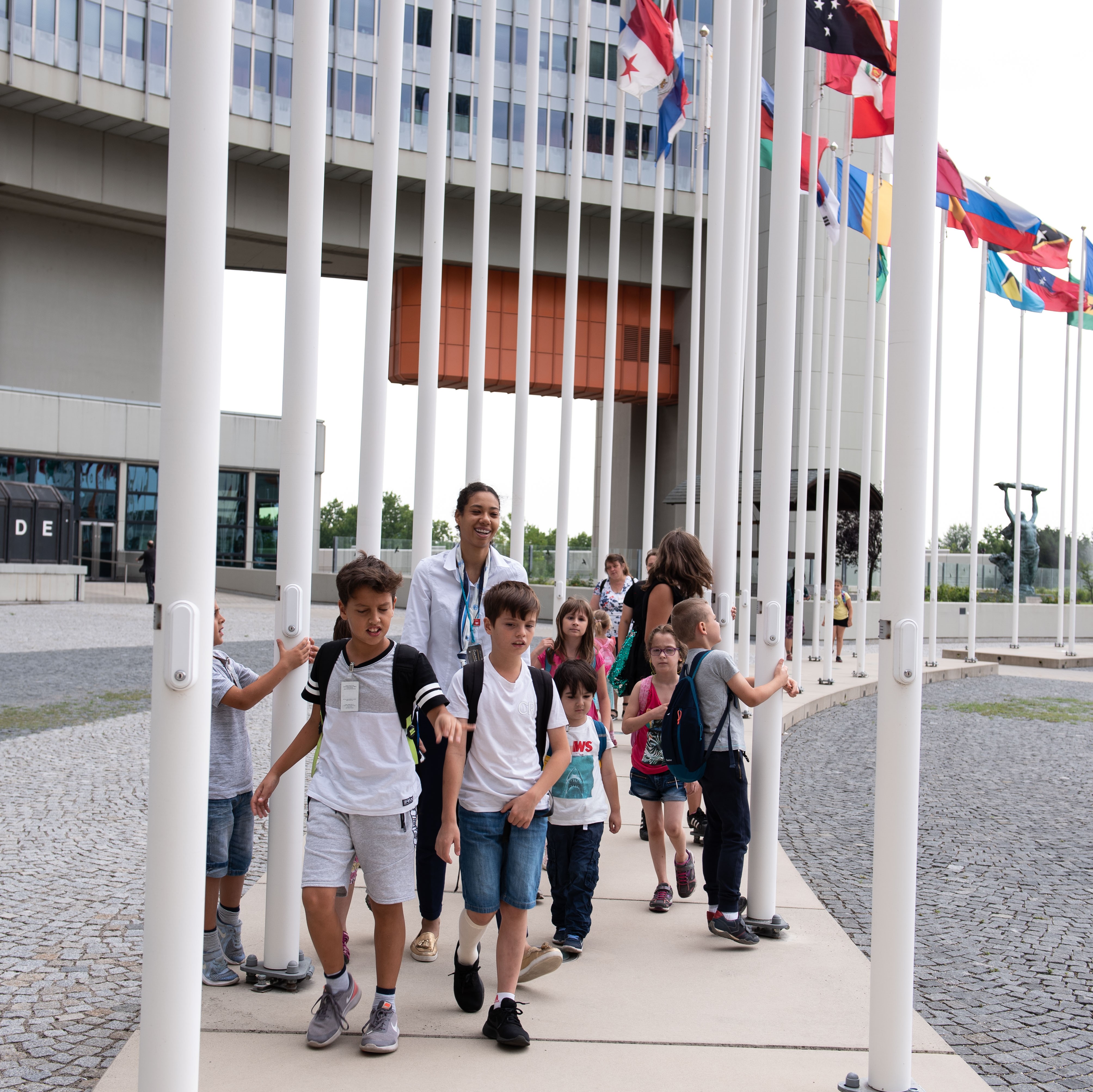 Kinder gehen an den Flaggen der Mitgliedsstaaten entlang