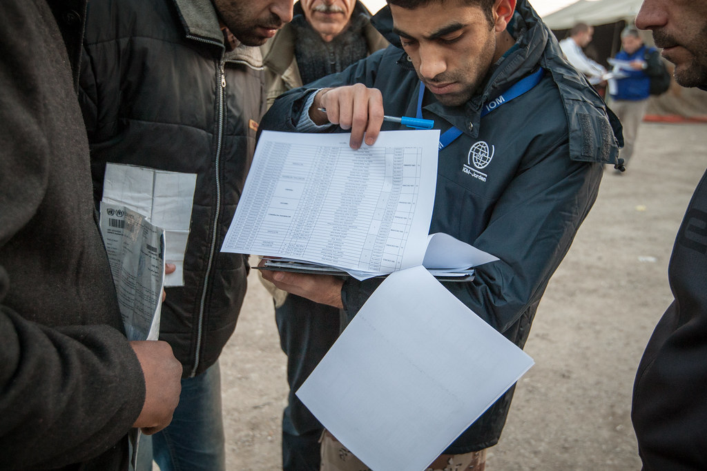 IOM staff speak with Syrian refugees