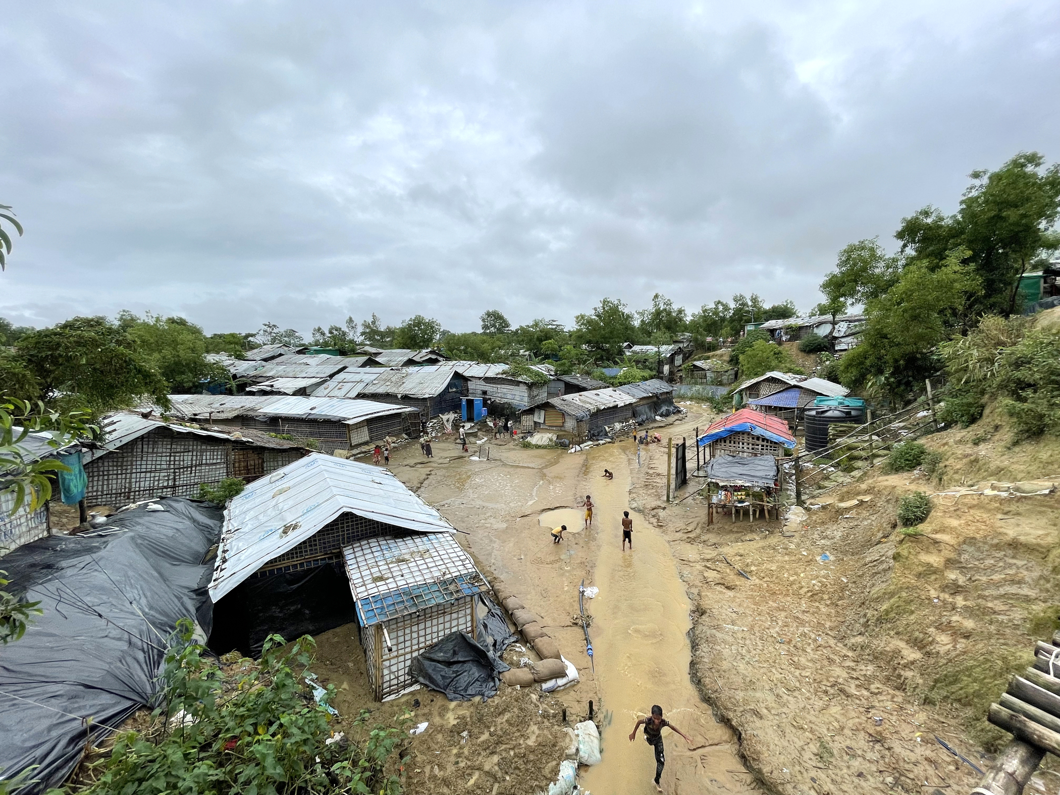 <p><sub>Rohingya refugee children play after the rain in Nayapara refugee camp in Teknaf, eastern Bangladesh. Heavy monsoon rains and strong winds caused flash floods and landslides in Rohingya refugee sites in Cox’s Bazar in July 2021.</sub></p>